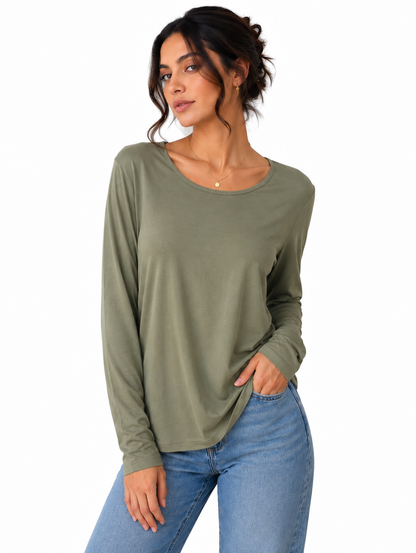 A woman modeling a long-sleeve crewneck top in olive green, paired with blue jeans, against a plain white background.