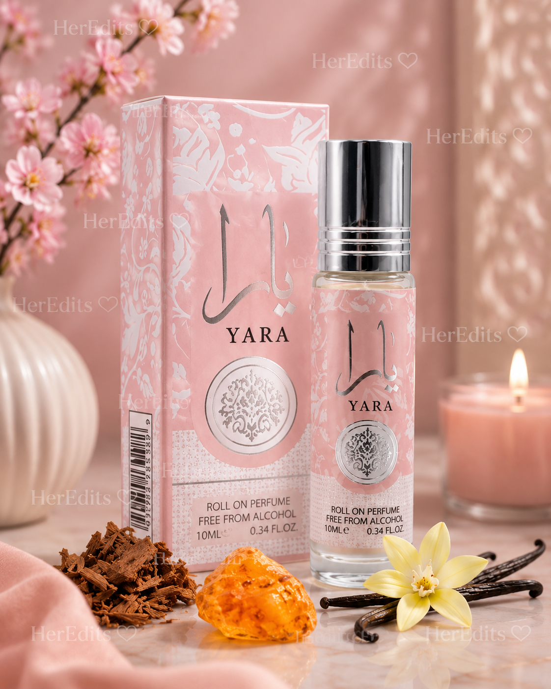 Yara 10ml alcohol-free roll-on perfume oil with matching pink box, styled with vanilla flower, vanilla pods, amber and woody accents on a soft blush pink background.